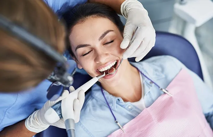 a woman in a dental chair during a teeth cleaning